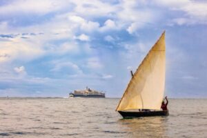 A traditional dhow sails past the cruise ship Diana off Pemba Island in the Zanzibar Archipelago