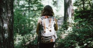 Hiker with a large backpack. Photo by Jake Melara, Unsplash