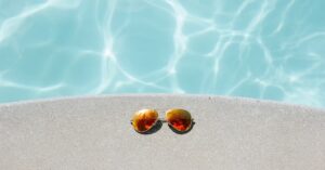 Sunglasses beside pool. Photo by David Lezcano, Unsplash